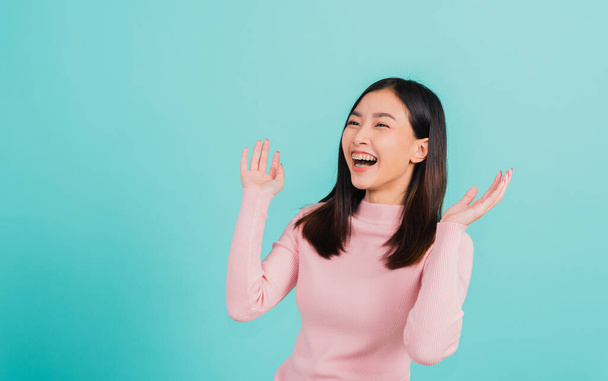 Happy young Asian beautiful woman smiling wear silicone orthodontic retainers on teeth surprised she is excited screaming and raise hand make gestures wow, studio shot isolated on blue background - Zdjęcie, obraz