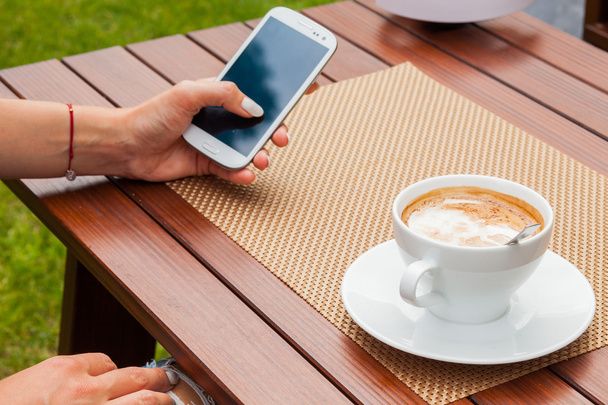 Mani donna con telefono cellulare e caffè
 - Foto, immagini