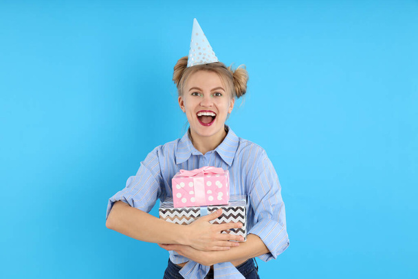 Concepto de feliz cumpleaños con la mujer joven sobre fondo azul - Foto, imagen