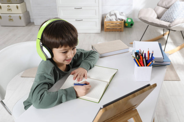 Cute little boy with modern tablet studying online at home. E-learning - Foto, immagini