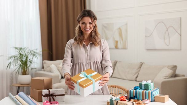 Young woman with beautiful gifts in living room - Foto, Imagem
