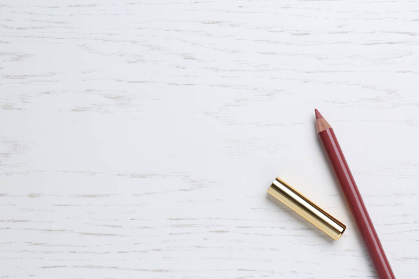 Lip pencil on white wooden table, flat lay with space for text. Cosmetic product - Foto, afbeelding