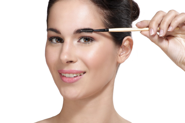 Beautiful young woman applying eyebrow brush - Фото, зображення