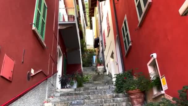 Uitzicht op de smalle straat in de Italiaanse stad met trappen en bloempotten aan de zijkant. - Video