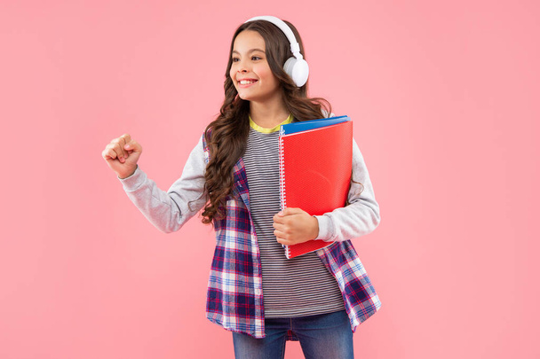 childhood development. child in modern earphones hold workbook. online education. - Фото, зображення