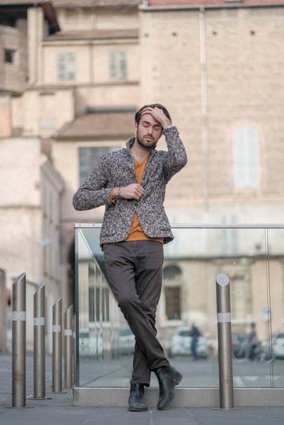 красивый элегантный итальянский темноволосый парень с курткой в центре Пармы. Высокое качество фото - Фото, изображение