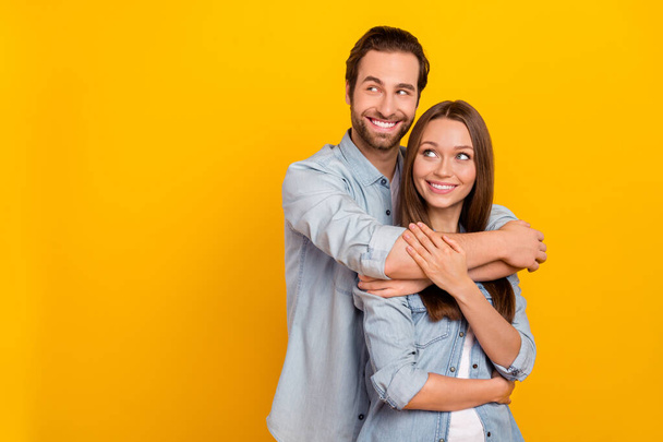 Portrait of attractive cheerful dreamy couple hugging looking idea copy space isolated over bright yellow color background - Photo, Image