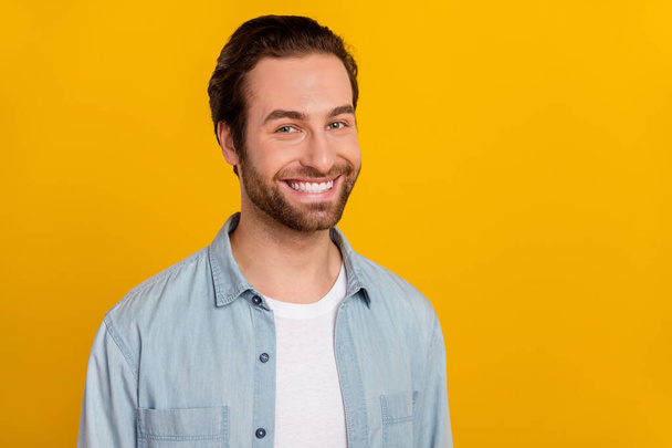 Photo of pretty attractive young man wear jeans shirt smiling empty space isolated yellow color background - Foto, Imagem