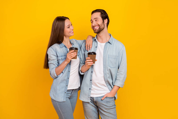 Photo of funny millennial brown hairdo couple drink americano wear trend cloth isolated on yellow background - Фото, зображення