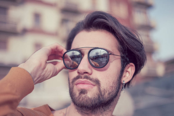Güzel, siyah saçlı, aynalı güneş gözlüklü bir İtalyan. Yüksek kalite fotoğraf - Fotoğraf, Görsel
