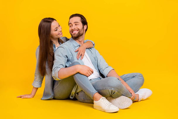 Portrait of two attractive cheerful cute people soulmate sitting hugging romance isolated over bright yellow color background - 写真・画像