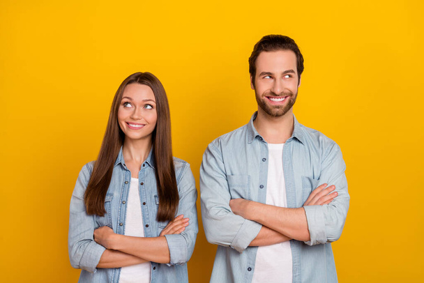 Photo of funny dreamy husband wife wear jeans shirts looking empty space arms folded isolated yellow color background - Φωτογραφία, εικόνα