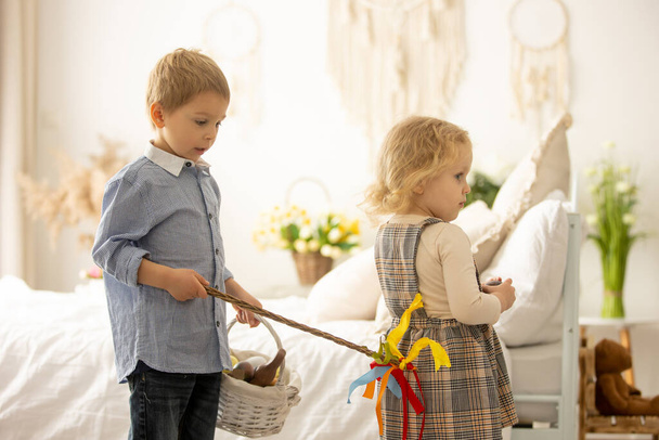 Happy children, siblings, enjoying Easter holiday together, tradition with handmade twig, braided whip made from pussy willow, traditional symbol of Czech Easter - Фото, изображение