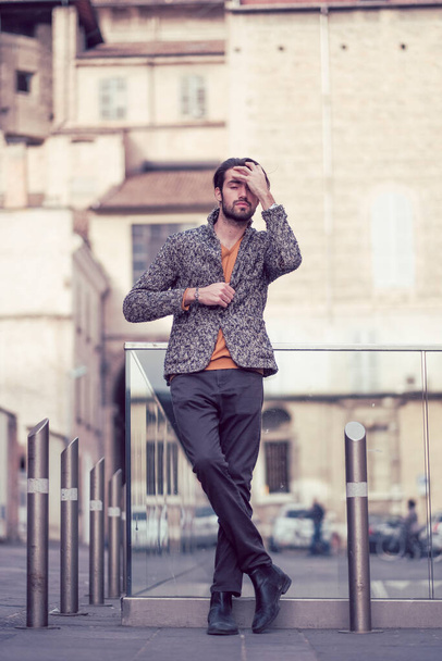 beautiful elegant Italian dark-haired guy with jacket in the center of Parma. High quality photo - Foto, Imagen