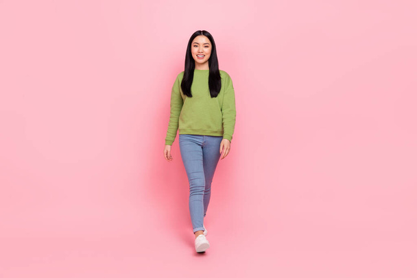 Full size photo of funky millennial lady go wear sweatshirt jeans sneakers isolated on pink color background - Photo, Image