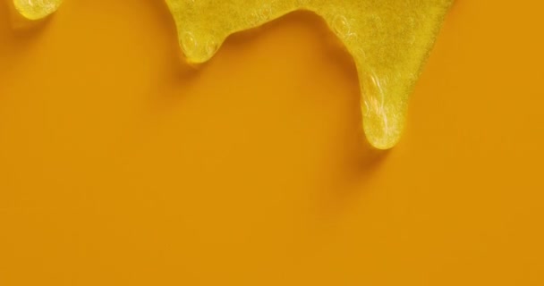Krem sıvısı jel serumu sarı doku, makyaj ve kozmetik arka plan, cilt veya saç ürünü üzerine akar - Video, Çekim