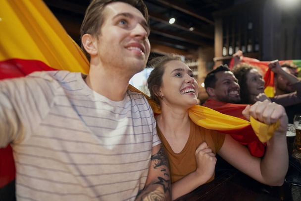 Group of friends cheering to soccer match in the pub - Photo, Image