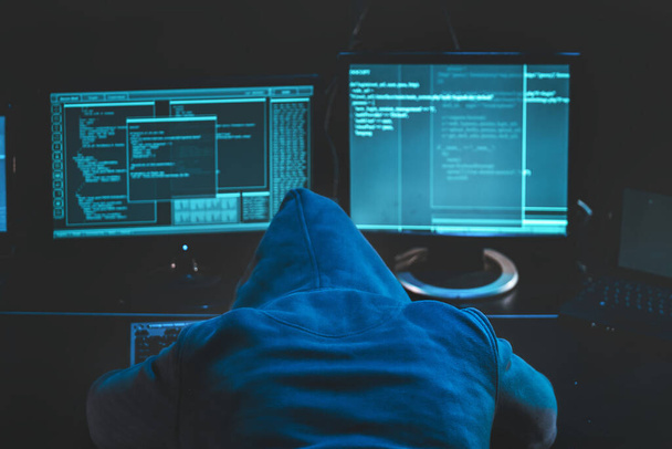 Overwerkte hacker. hooded hacker slapen op zijn computer, kwaadaardige code software op het scherm hacken datacenter. Afbeelding downloaden - Foto, afbeelding