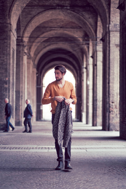 mooie elegante Italiaanse donkerharige jongen met jas in het centrum van Parma onder de bogen van de Pilotta. Hoge kwaliteit foto - Foto, afbeelding