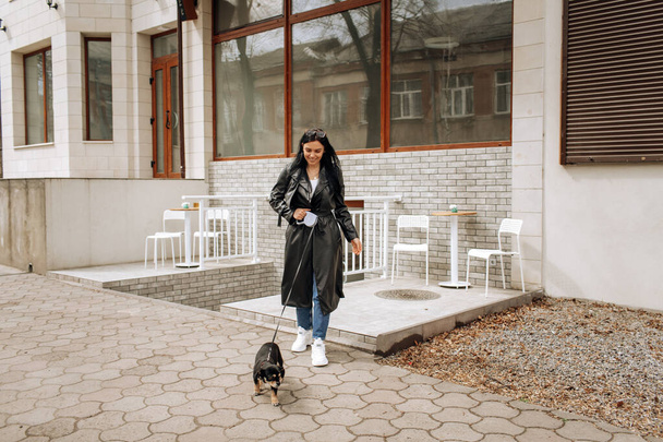 beautiful girl model walks the dog in the city. High quality photo - Фото, изображение