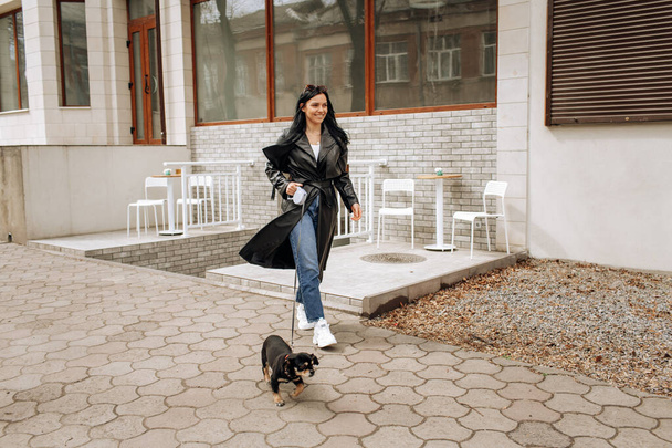 beautiful girl model walks the dog in the city. High quality photo - 写真・画像