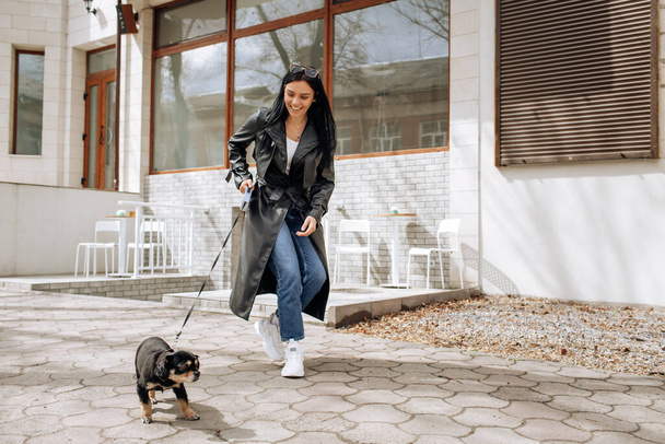piękna dziewczyna model spacery psa w mieście. Wysokiej jakości zdjęcie - Zdjęcie, obraz
