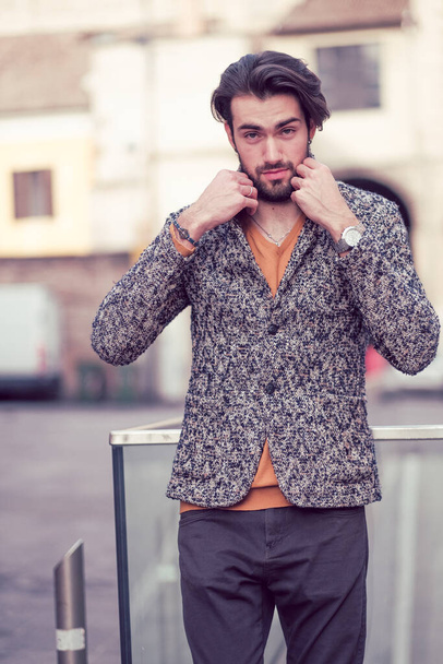 hermoso chico italiano de pelo oscuro elegante con chaqueta en el centro de Parma. Foto de alta calidad - Foto, imagen