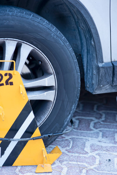 Egy sárga kerékbilincs a gumin. bírság és bírság szabálytalan parkolás esetén. - Fotó, kép