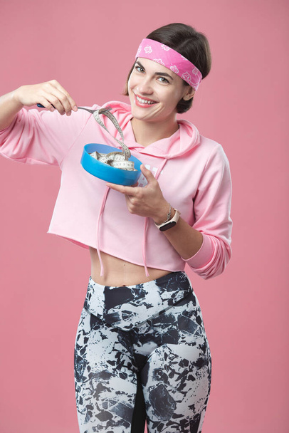 Porträt eines charmanten weißen Mädchens mit einem Teller in der Hand und einem Zentimeter auf einer Gabel. Richtige Ernährung und ein gesunder Lebensstil. Mädchen auf Diät. - Foto, Bild