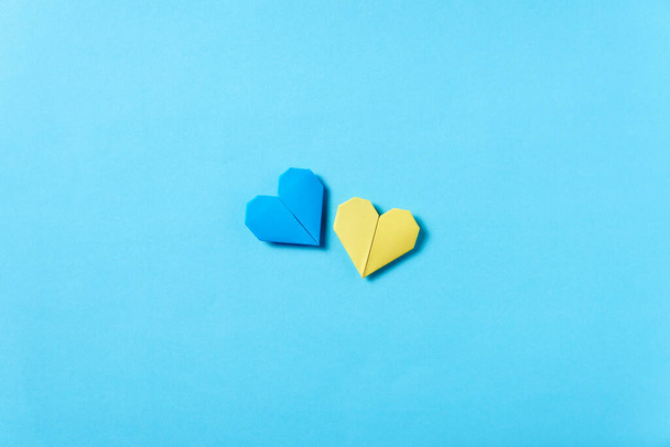 Sininen ja keltainen origami sydämet, värit Ukrainan lipun. Käsitteellinen symbolinen kuva tukee tätä maata Venäjän sotilaallisen hyökkäyksen aikana. Solidaarisuus, rauha Ukrainalle. - Valokuva, kuva