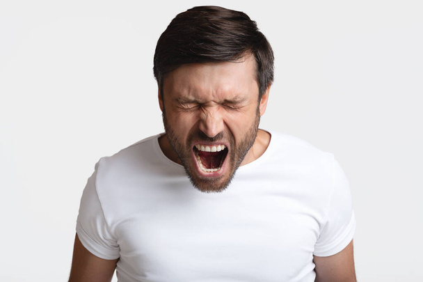 Mad Male Shouting Loudly In Anger With Eyes Closed, Studio - 写真・画像