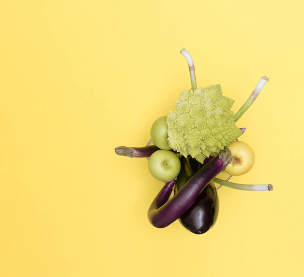 Organic rat tail (purple) radish in the shape of an exclamation mark and Romanesque cauliflower on a yellow background. Healthy vitamin food. - Photo, image
