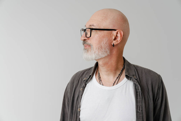 Bald european man in eyeglasses posing and looking aside isolated over white background - Fotó, kép