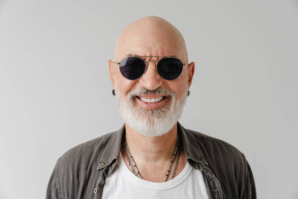 Bald european man in sunglasses laughing and looking at camera isolated over white background - Photo, image