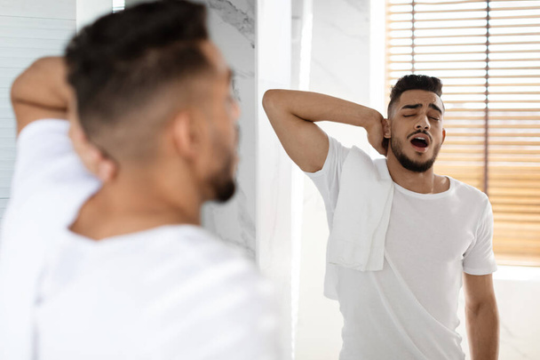 Lazy Morning. Portrait Of Sleepy Young Arab Man Yawning In Bathroom - 写真・画像