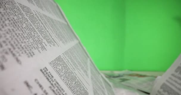 Makroaufnahme eines Zeitungsartikels vor grünem Bildschirm - Filmmaterial, Video