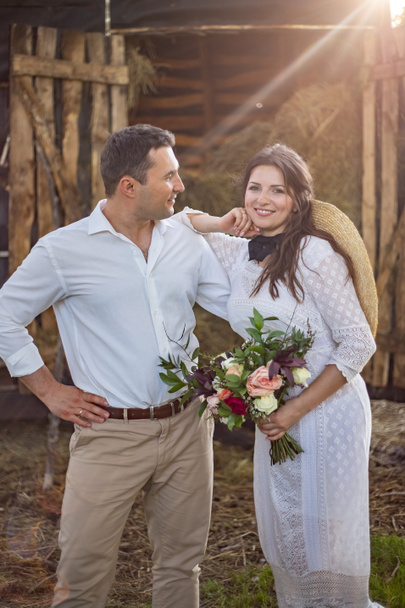 bride in cowboy style sits on threshold of hayloft - Photo, Image