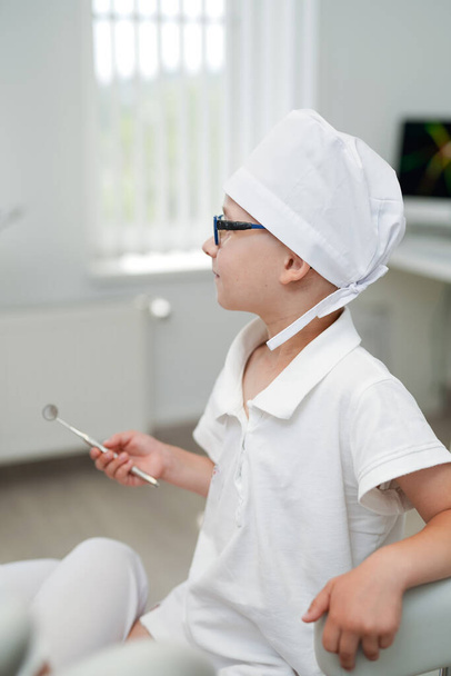 Oral child dental uniform. Mouth healthcare little dentist boy in medical coat. - Foto, afbeelding