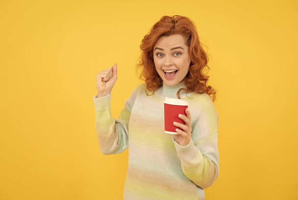 boldog vörös hajú lány inni elvitelre kávé csésze sárga háttér, reggel - Fotó, kép