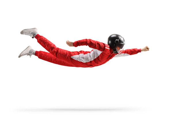Car racer in a red suit and black helmet flying isolated on white background - Фото, изображение
