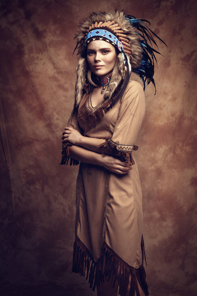 Mujer pintada y vestida en estilo nativo americano en estudio con maquillaje profesional - Foto, imagen