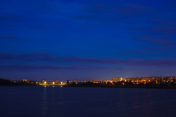 Gece bir nehir ya da gölden şehrin manzarası. Büyük bir şehrin gece manzarası - Fotoğraf, Görsel