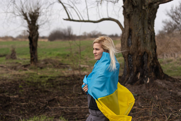 woman flag of ukraine near burnt tree - Photo, Image