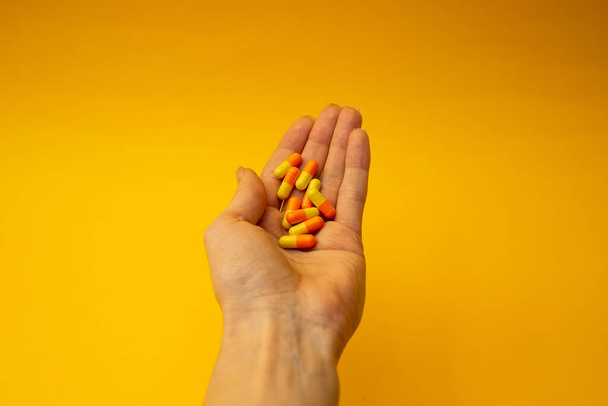 A girl holding a pill in her hand - Φωτογραφία, εικόνα