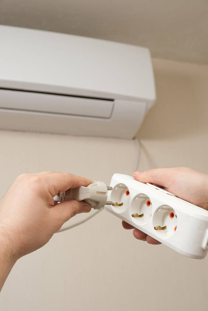 Osoba zapojí klimatizaci do zásuvky - Fotografie, Obrázek