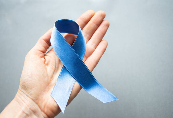 blue ribbon in hand prostate cancer awareness - Foto, Bild