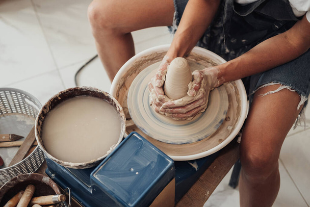 Folyamat létrehozása Clay Pot, felismerhetetlen női mester dolgozik egy fazekas kerék a stúdióban - Fotó, kép