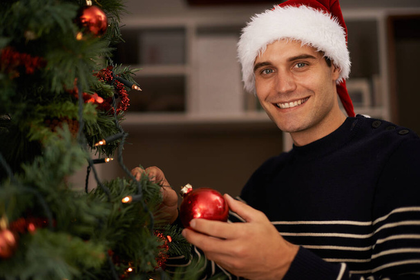 Preparando el árbol. Foto de un joven guapo preparándose para la Navidad. - Foto, Imagen