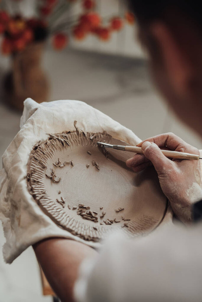 Close Up of Artista de cerâmica feminina no trabalho, Mulher criando padrões em uma placa de barro, Obra de arte em processo - Foto, Imagem