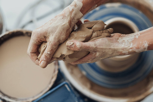 Close Up of Female Hands Holding Pile of Clay, vista de cima para baixo em um mestre de cerâmica no trabalho - Foto, Imagem
